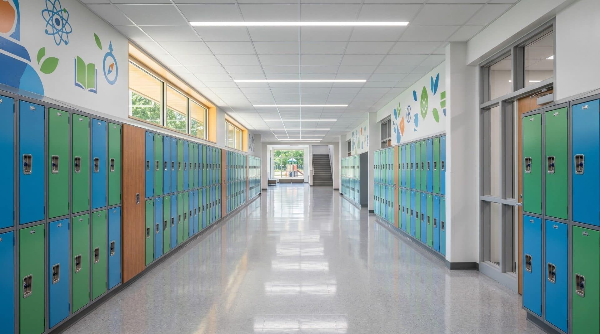 School hallway with bright lockers, polished floors, and natural daylight